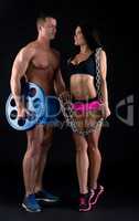 Bodybuilder and sporty girl looking at each other