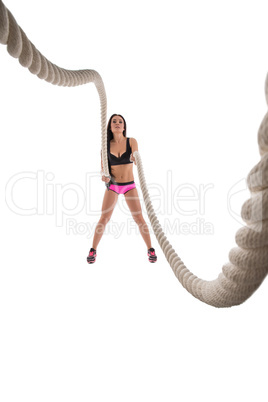 Studio photo of sporty woman training with rope