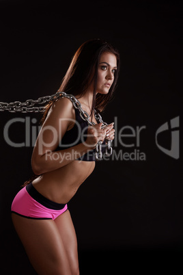 Image of sexy female athlete exercising with chain
