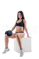 Sexy woman posing while exercising with dumbbells