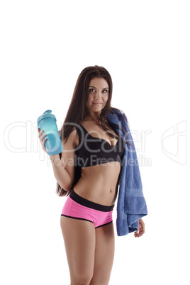 Sporty woman posing with shaker and towel