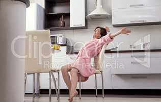 Woman stretching herself in morning on kitchen