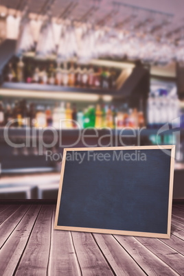 Composite image of wine glasses suspended on a rack against bott