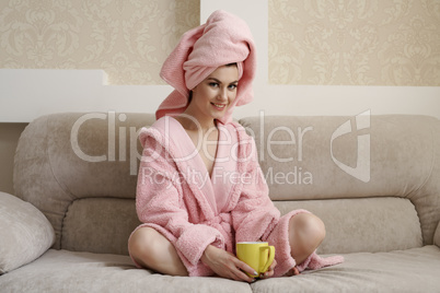 Nice woman in comfortable clothes, sitting on sofa