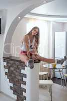 Cute model sitting at bar rack in kitchen