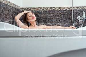Relaxing at home. Beautiful brunette taking bath