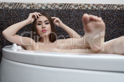 Image of lovely brunette posing while taking bath