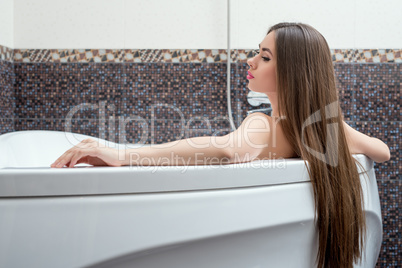 Image of sexy long-haired brunette taking bath