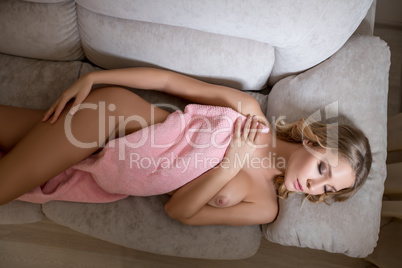 Top view of sexy nude blonde sleeping on sofa
