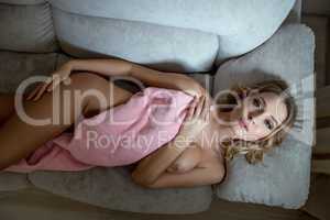Top view of languid nude blonde lying on sofa