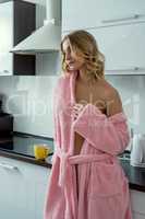 Relaxed sexy blonde posing on kitchen in morning