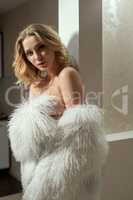 Pretty blonde covers her nakedness with faux fur