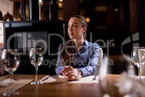 Nice woman posing while sitting at table in cafe