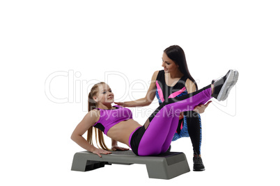 Fitness coach helping girl do exercise on stepper