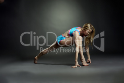 Sexy blonde doing stretching exercises in studio