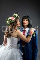 Lesbian bride and groom posing at camera