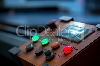 Close-up of red button lit on control panel
