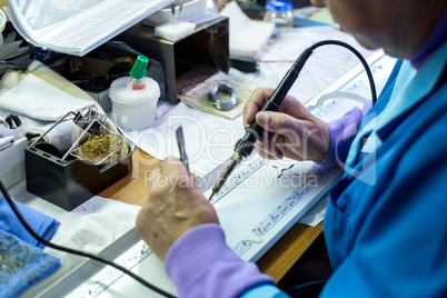 Manufacturing. Worker soldering circuit board