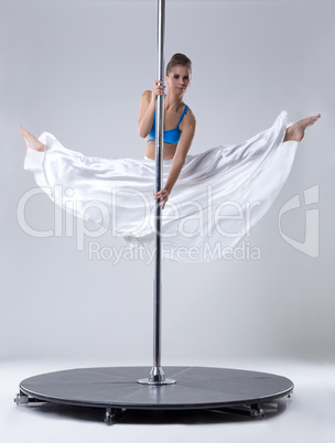 Pole dance. Flexible woman posing in split