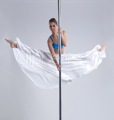 Flexible girl doing gymnastic split on pylon