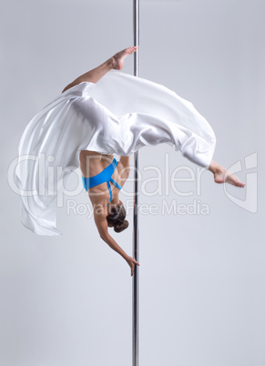 Graceful girl hanging upside down on pylon
