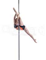 Lovely female dancer performs split on pylon
