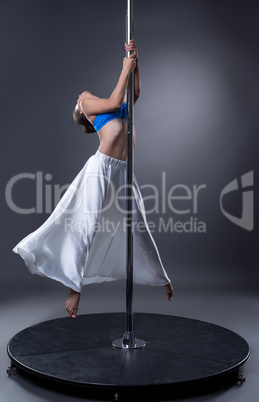 Pole dance. Graceful dancer hung on pylon