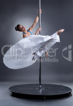 Pole dance. Sexy woman posing in elegant position