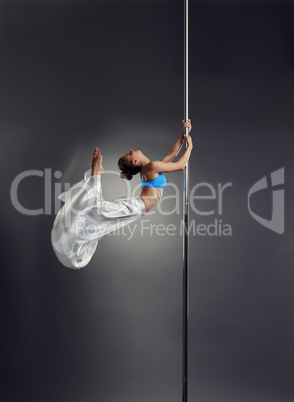 Studio photo of petite woman dancing on pole