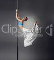 Pretty dancer bent elegantly while dancing on pole