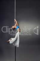 Petite woman dancing on pylon in studio