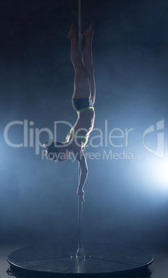 Image of dancer hanging upside down on pylon