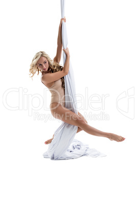 Playful girl posing while dancing on aerial silks