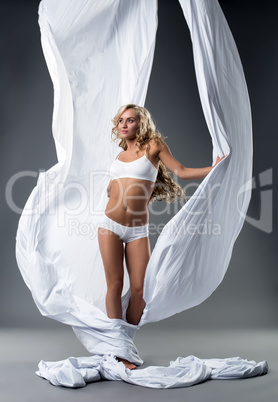 Girl posing and aerial silks fluttering in studio