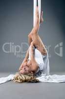 Naked blonde dancing on aerial silk. Studio shot