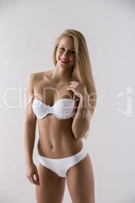Smiling underwear model posing with bare shoulder