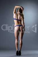 Back view of slender woman in purple underwear