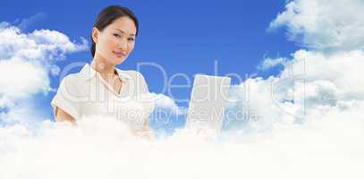 Composite image of asian businesswoman using laptop