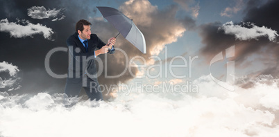 Composite image of man holding umbrella to protect himself from