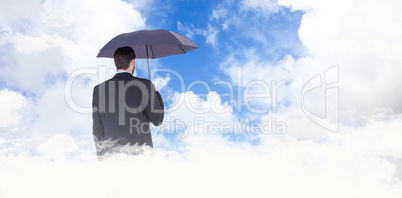 Composite image of businesswoman in suit holding umbrella