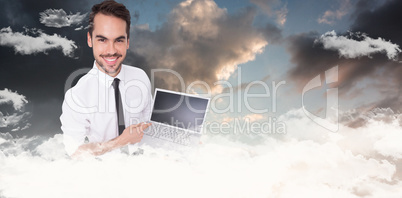 Composite image of smiling businessman pointing his laptop