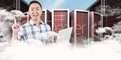 Composite image of happy man holding laptop and pointing