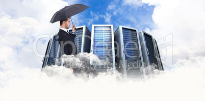 Composite image of businessman holding briefcase under umbrella