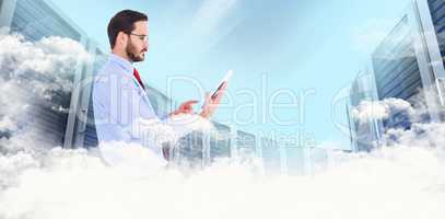 Composite image of businessman scrolling on his digital tablet