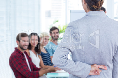 Composite image of businesswoman with fingers crossed behind her