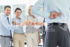 Composite image of businessman crossing fingers behind his back