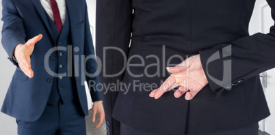 Composite image of businesswoman with fingers crossed behind her