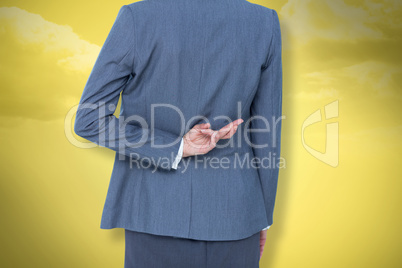 Composite image of businesswoman with fingers crossed behind her