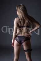 Harmonous woman in black lingerie with garter