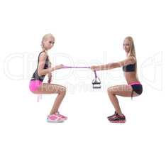 Squats. Two sexy blondes exercising with expander
